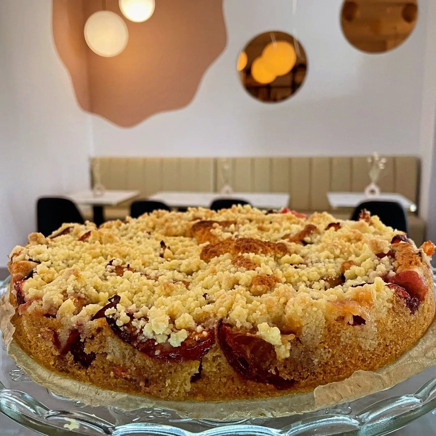 Frischer Streuselkuchen mit Pflaumen auf Glasplatte im Hey Fede! Dessertbar & Café Wetzlar