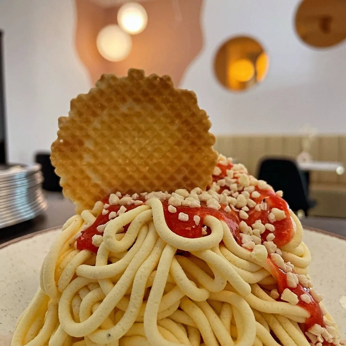 Spaghetti-Eis mit Erdbeer-Sauce, Waffelscheibe und weißen Streuseln bei Hey Fede! Eiscafé Wetzlar